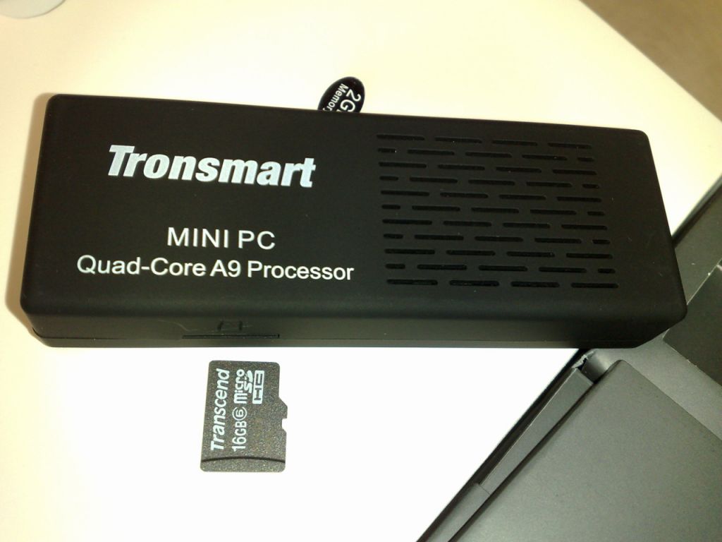 Quad-core Android -mini PC- with a microSD card next to it for a size comparison