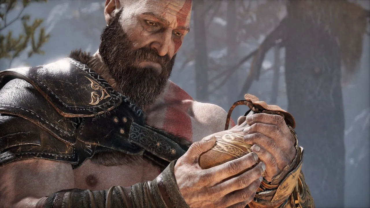 Kratos is holding a bag of ashes and looks at it solemnly. 