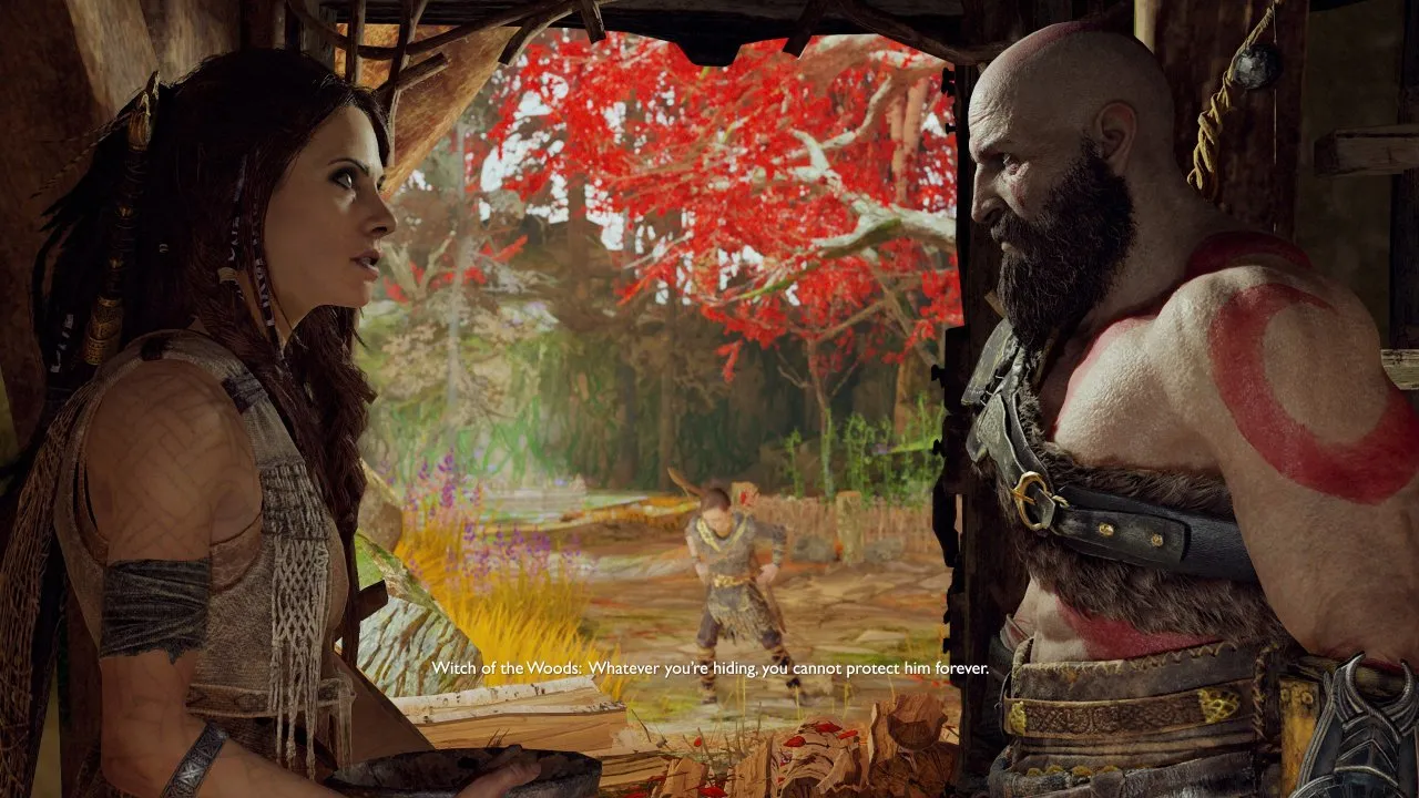 Kratos is seen speaking to the Witch of the Woods. In the background Atreus is playing.