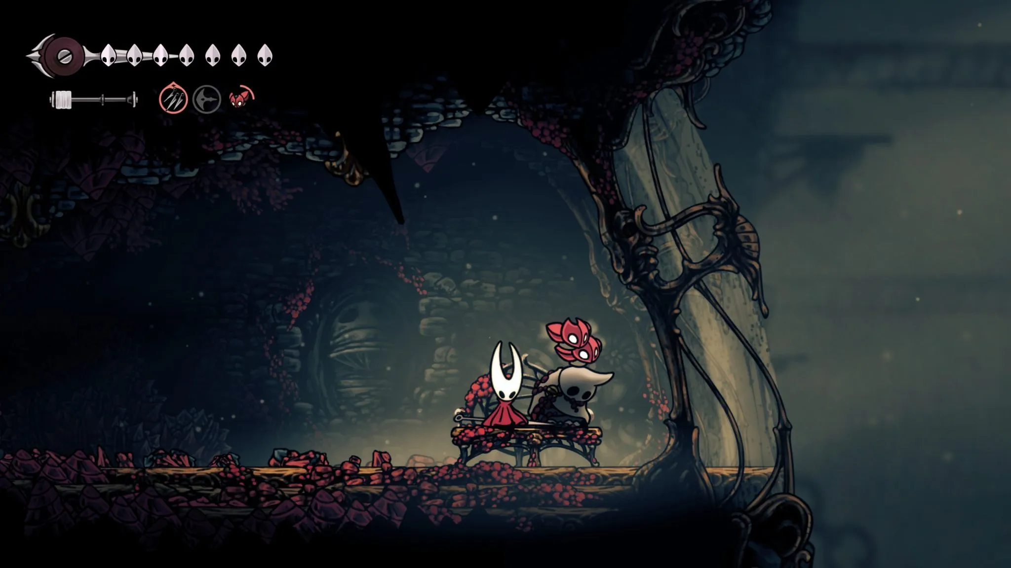 Hollow Knight: Silksong - The image shows the protagonist, Hornet, taking a rest on a bench alongside a dead pilgrim bug.